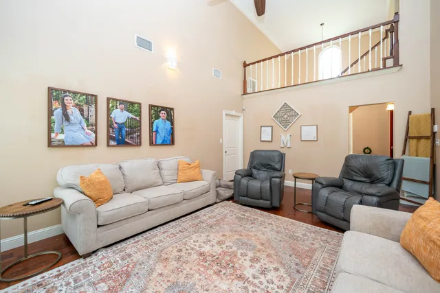 a living room with furniture and paintings on the wall