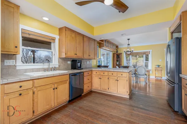 a large kitchen with cabinets and wooden floor