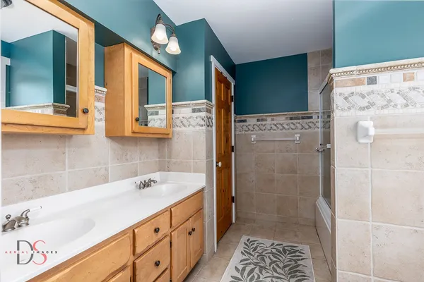 a bathroom with a tub sink and mirror
