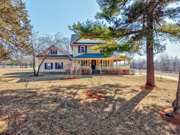 a front view of a house with a yard tree and wooden fence