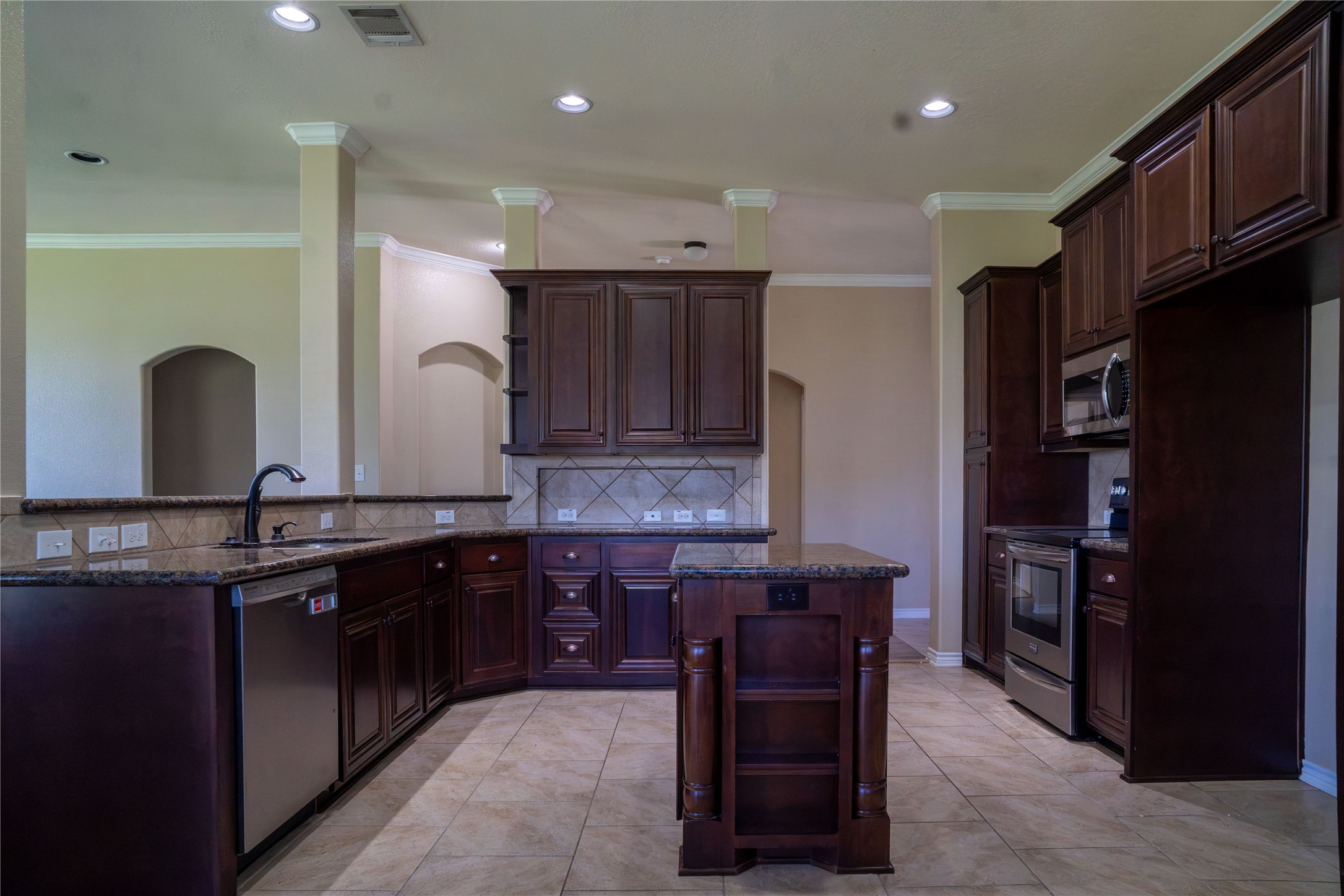 119 Hackberry Street Louise, TX 77455 - Photo 12 of 31 a kitchen with kitchen island granite countertop a sink a counter space appliances and cabinets