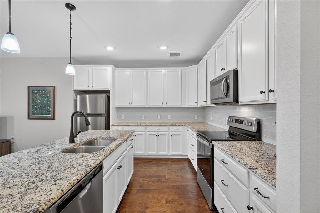 651 Watters Road, Unit 5305 Allen, TX 75013 - Photo 6 of 40 a kitchen with stainless steel appliances granite countertop a sink stove and refrigerator