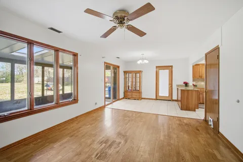an empty room with windows and fan