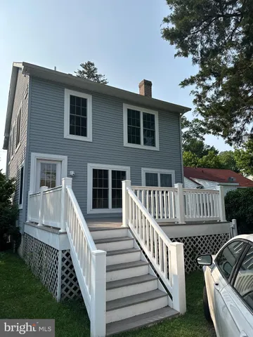 a view of a house with wooden deck and a yard