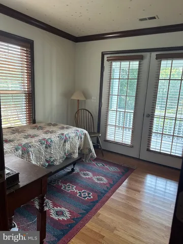 a bedroom with a bed and wooden floor