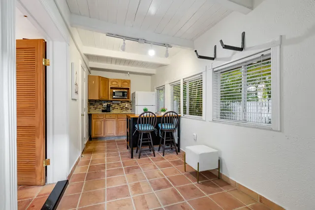 a dining room with stainless steel appliances furniture a window and a kitchen view