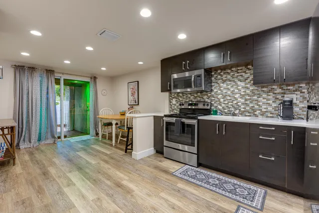 a kitchen with stainless steel appliances kitchen island granite countertop a refrigerator and a sink