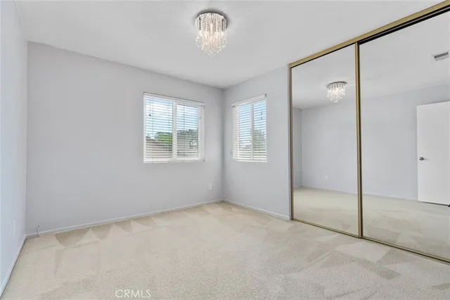 an empty room with windows and closet