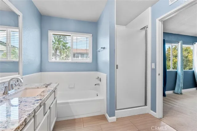 a bathroom with a granite countertop tub sink and a window