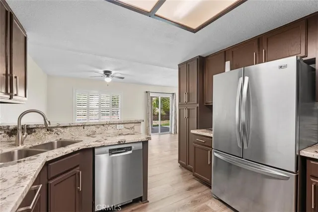 a kitchen with stainless steel appliances granite countertop a refrigerator sink and stove