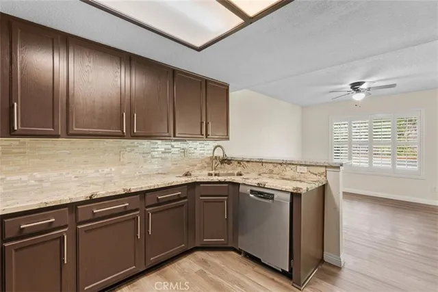 a kitchen with granite countertop stainless steel appliances sink stove and cabinets