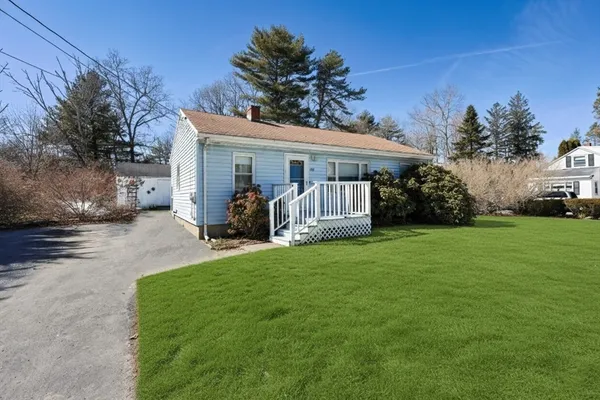 a view of a house with backyard and a tree