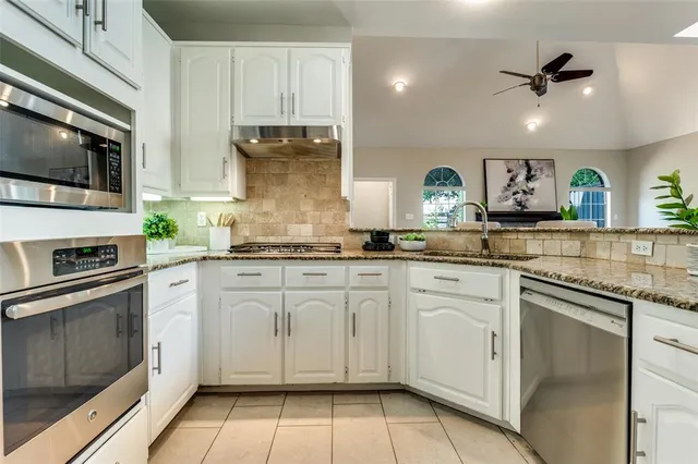 a kitchen with cabinets stainless steel appliances and a sink