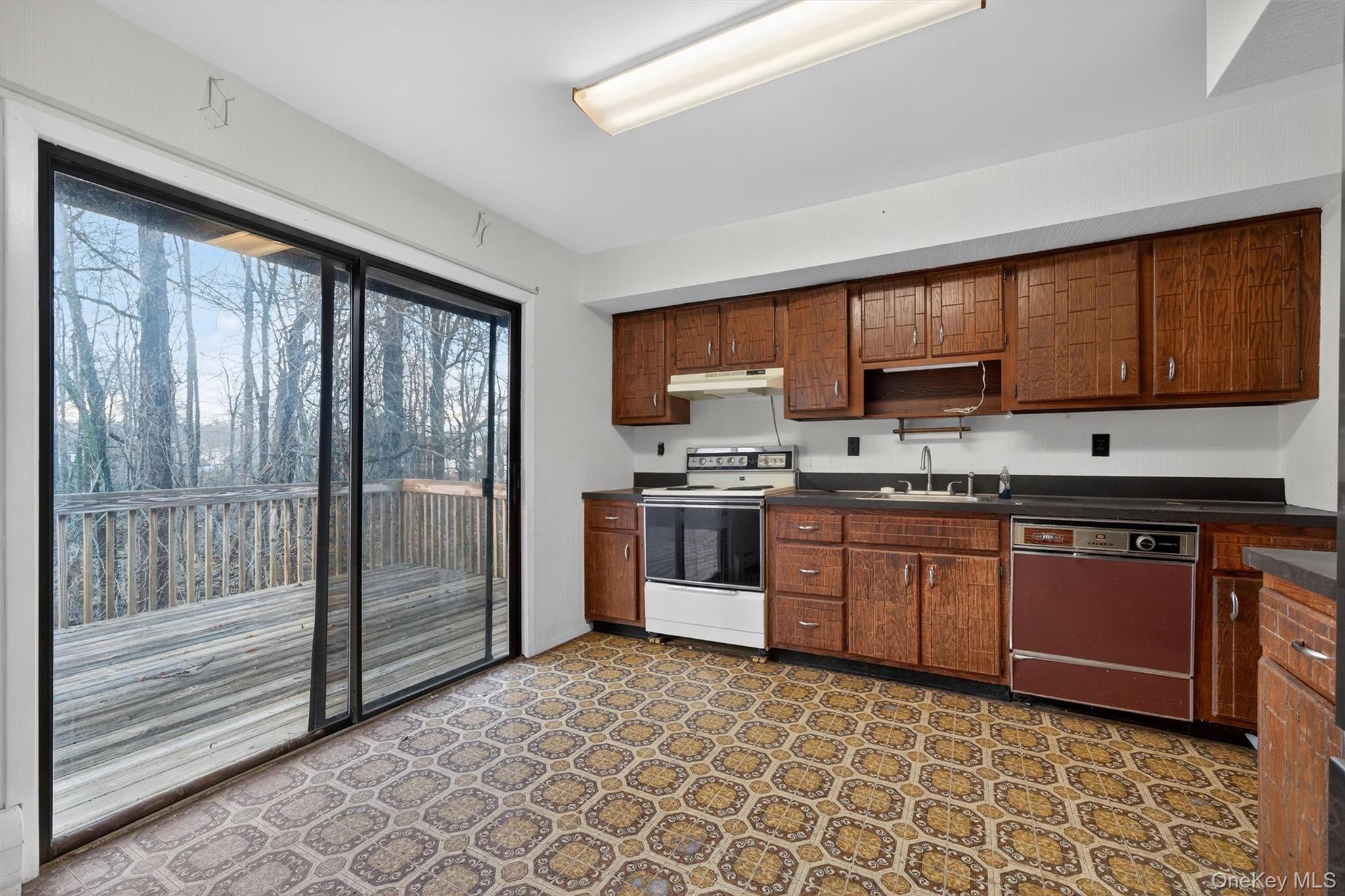 53 Mallory Road Spring Valley, NY 10977 - Photo 11 of 33 Kitchen featuring dark countertops, white electric range, light flooring, open shelves, and under cabinet range hood