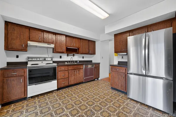 a kitchen with stainless steel appliances granite countertop a refrigerator stove top oven a sink and dishwasher