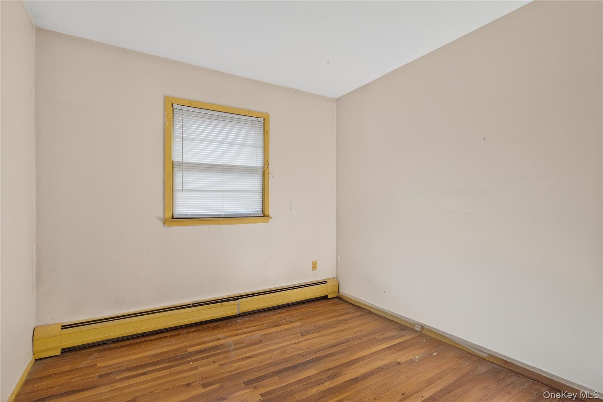 53 Mallory Road Spring Valley, NY 10977 - Photo 15 of 33 Unfurnished room with baseboard heating and wood-type flooring