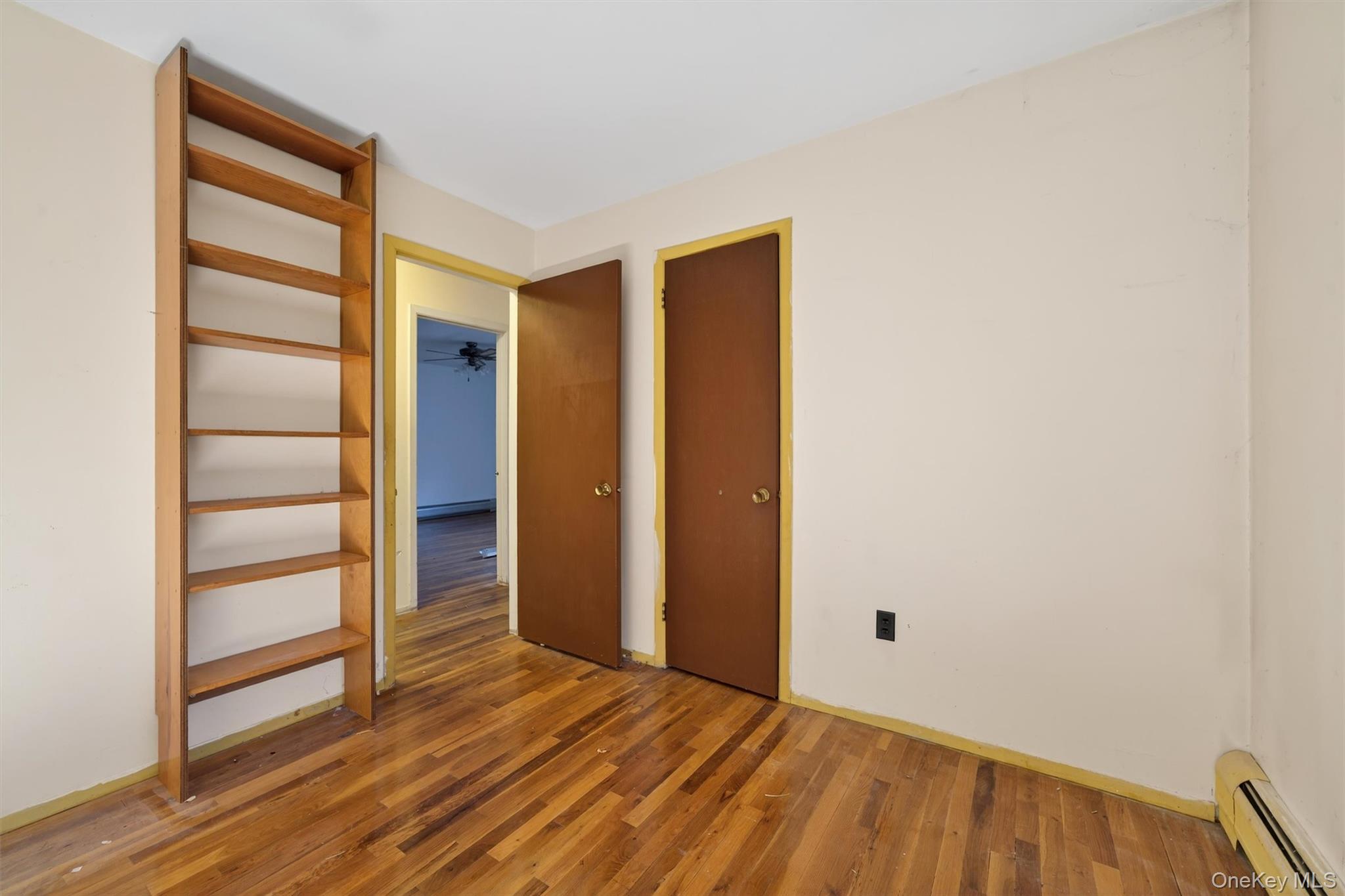53 Mallory Road Spring Valley, NY 10977 - Photo 16 of 33 Unfurnished bedroom featuring baseboard heating and wood finished floors