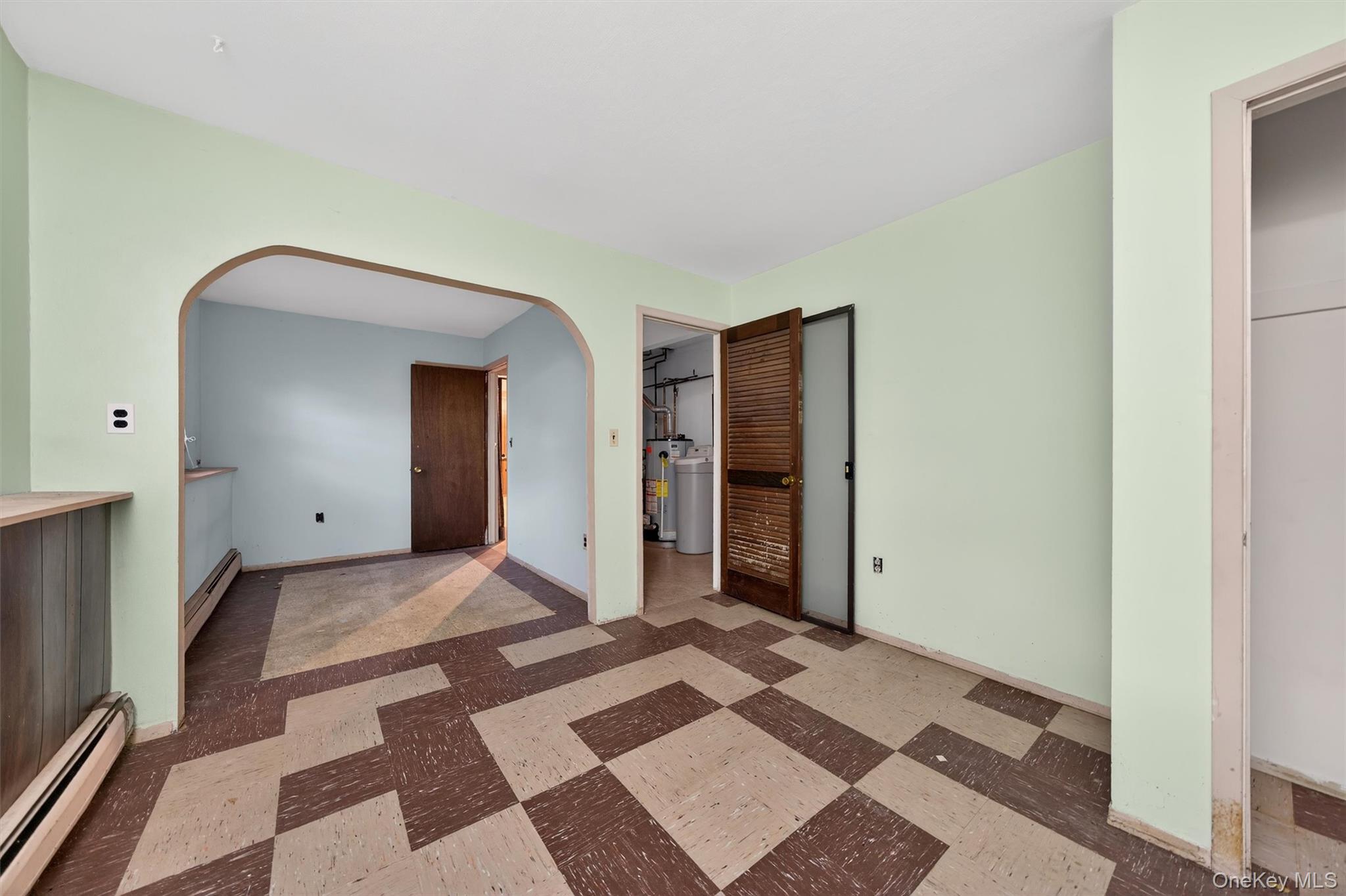 53 Mallory Road Spring Valley, NY 10977 - Photo 26 of 33 Unfurnished bedroom featuring a baseboard heating unit, tile patterned floors, and arched walkways