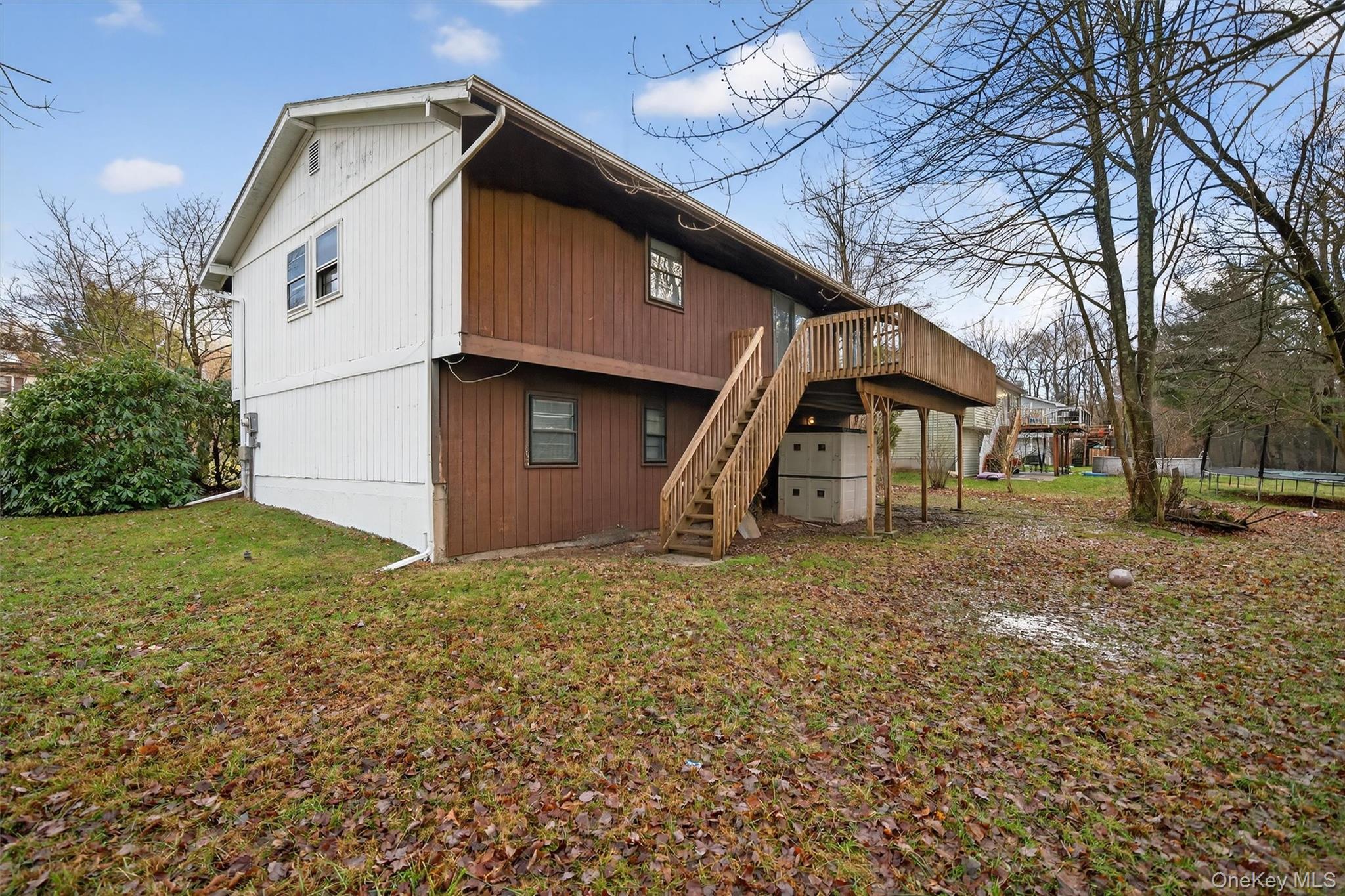 53 Mallory Road Spring Valley, NY 10977 - Photo 31 of 33 Rear view of house with a trampoline, stairs, a deck, and a yard