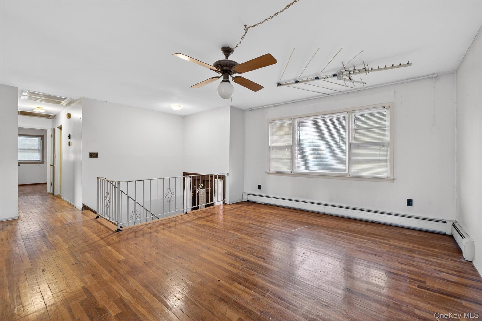 53 Mallory Road Spring Valley, NY 10977 - Photo 6 of 33 Empty room with wood-type flooring, a baseboard heating unit, and ceiling fan