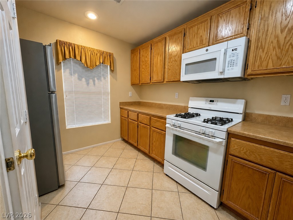 1172 Gecko Road Henderson, NV 89002 - Photo 5 of 30 A well-appointed kitchen features ample cabinetry, a full range of appliances, and practical tiled flooring.