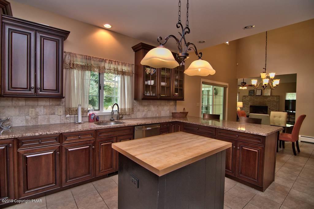 2169 Fox Run Road Stroudsburg, PA 18360 - Photo 17 of 66 a kitchen with a stove a sink dishwasher a dining table and chairs with wooden floor