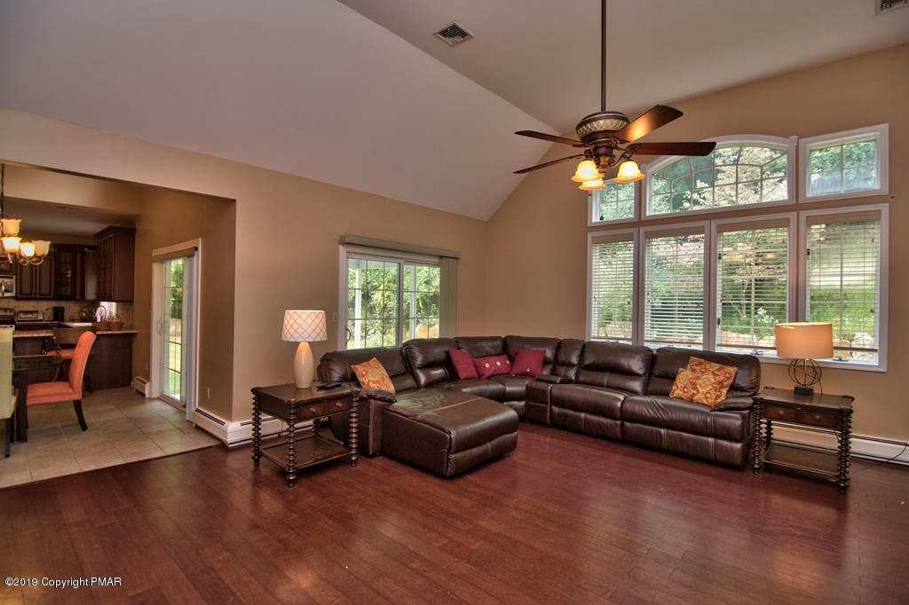 2169 Fox Run Road Stroudsburg, PA 18360 - Photo 22 of 66 a living room with furniture a ceiling fan a fireplace and a large window