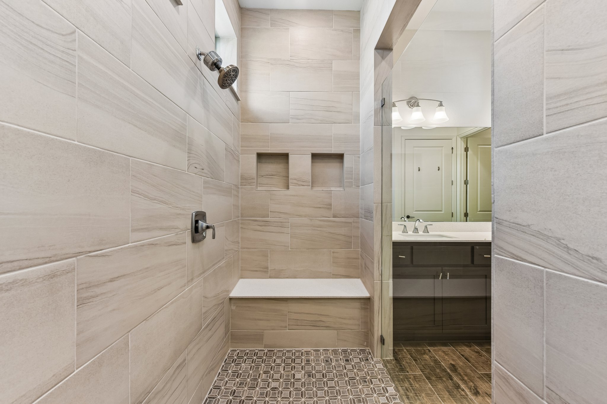 19113 Freeman Circle Austin, TX 78738 - Photo 8 of 37 A generously sized walk-in shower features integrated seating and dual recessed niches for convenience.