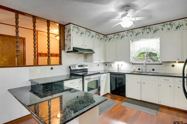 a kitchen with a table chairs microwave and cabinets