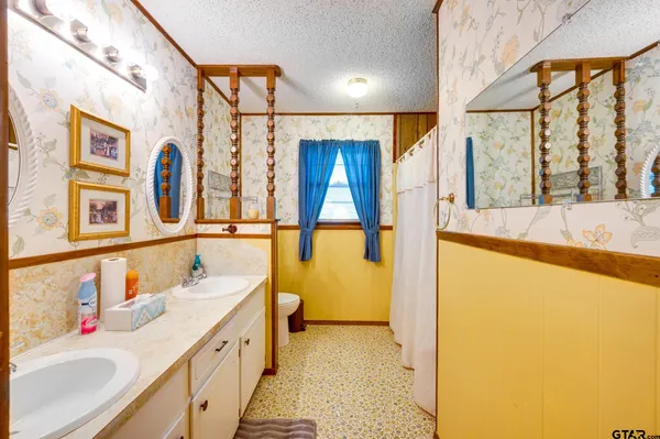 a view of a house with a yard and large tree