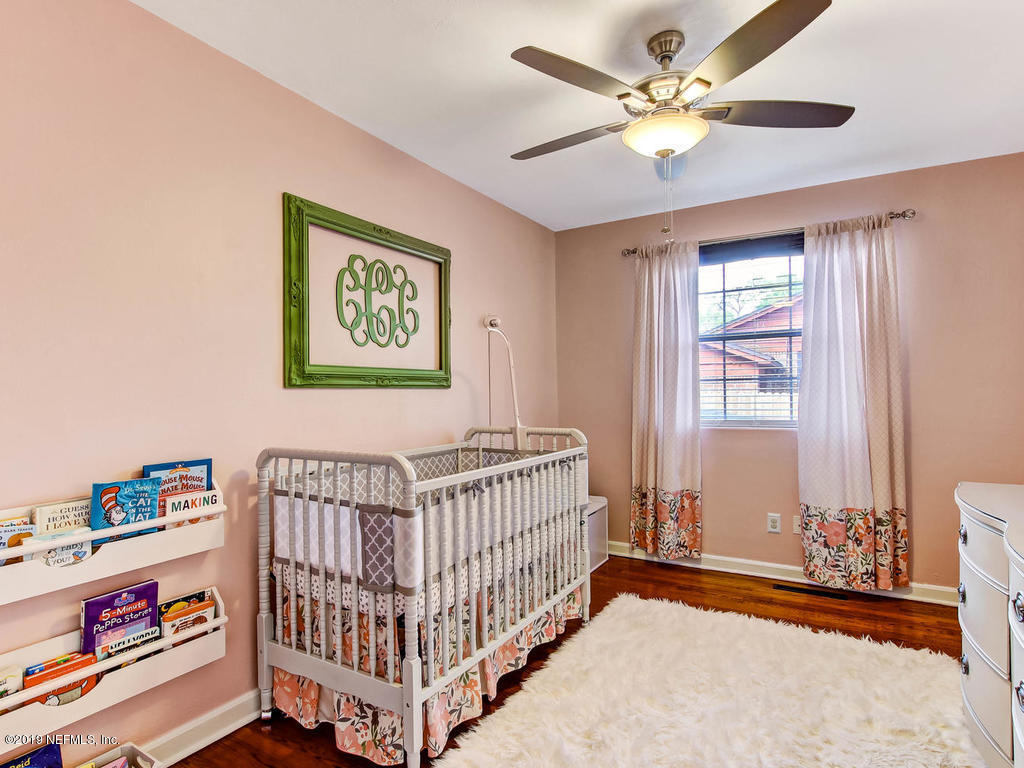 4061 Dover Road Jacksonville, FL 32207 - Photo 25 of 40 a bedroom with a bed and a chandelier