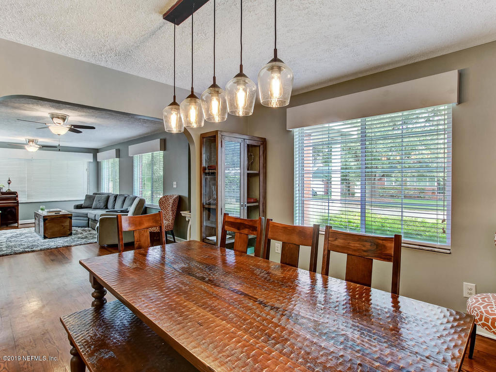 4061 Dover Road Jacksonville, FL 32207 - Photo 5 of 40 a dining room with wooden floor a chandelier a wooden table and chairs