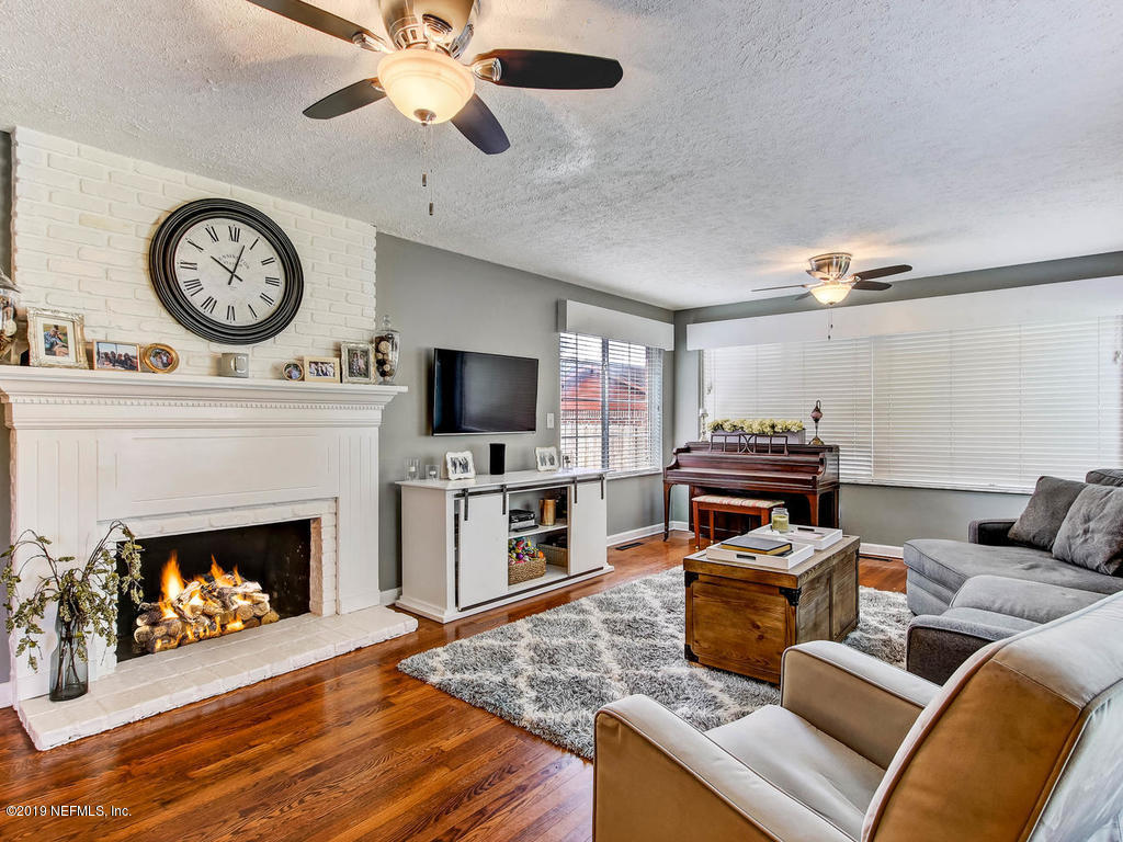 4061 Dover Road Jacksonville, FL 32207 - Photo 8 of 40 a living room with furniture a clock and a flat screen tv