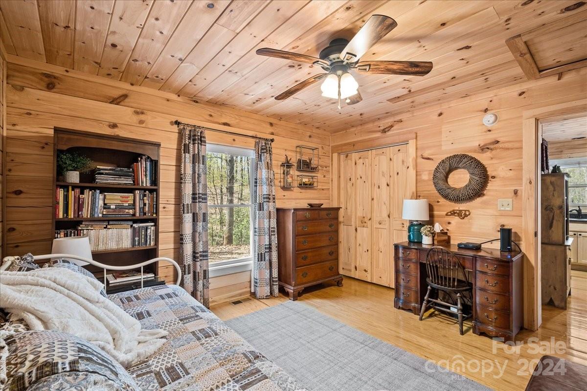 440 Jervey Road Landrum, SC 29356 - Photo 15 of 29 a bedroom with a bed a desk and chair with wooden floor