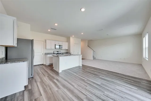 a large kitchen with kitchen island a sink stainless steel appliances and cabinets