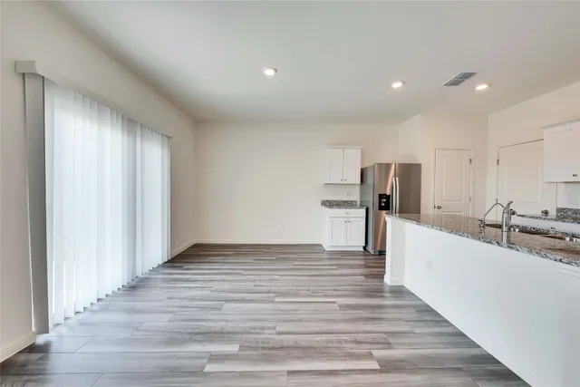 a view of kitchen with refrigerator microwave and wooden floor