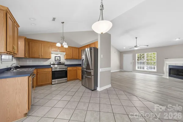 a kitchen with stainless steel appliances granite countertop a refrigerator a stove a sink dishwasher and a refrigerator