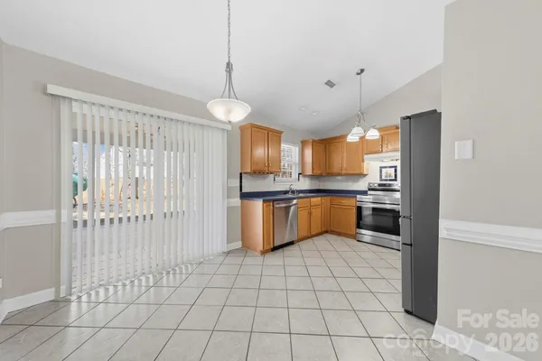 a kitchen with stainless steel appliances granite countertop a refrigerator a sink and a stove