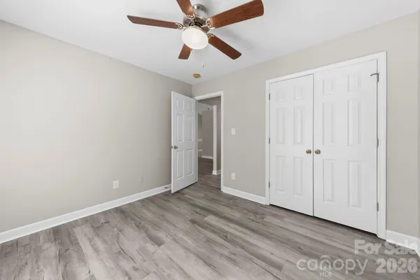 an empty room with a ceiling fan and a window