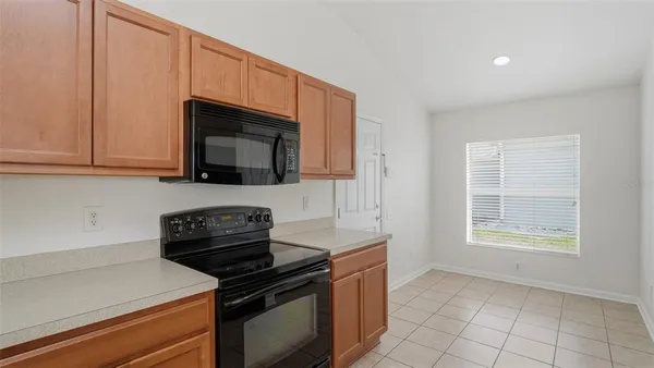 a kitchen with granite countertop a stove and a microwave