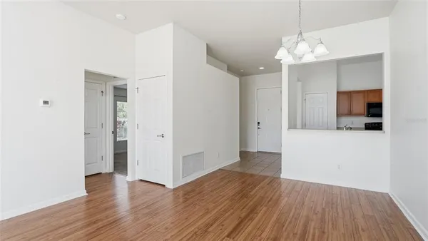 an empty room with wooden floor and mirror