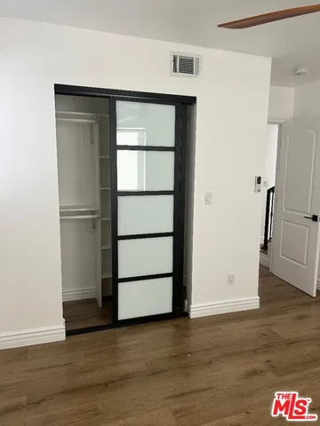 a view of empty room with wooden floor