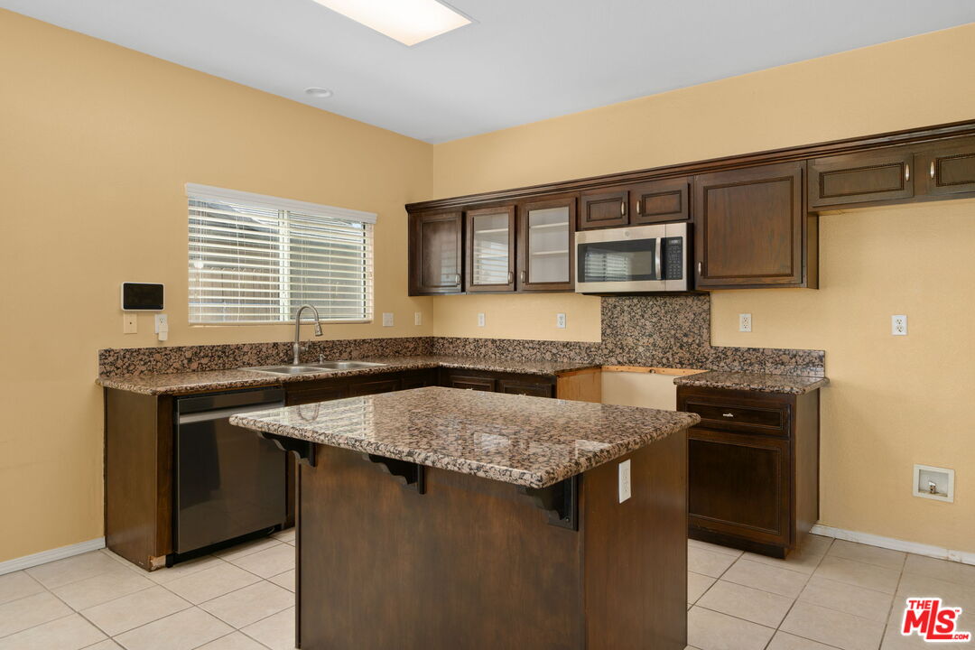 13623 Fox Point Road Victorville, CA 92392 - Photo 11 of 33 a kitchen with a stove a sink and a microwave