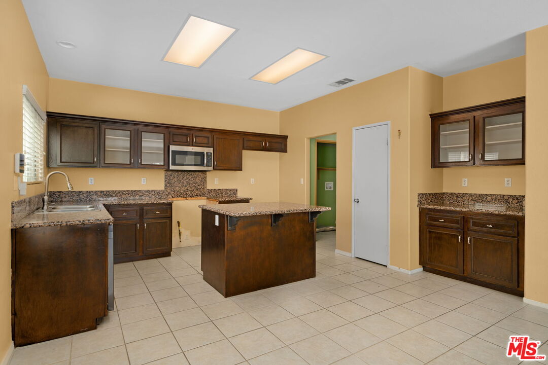 13623 Fox Point Road Victorville, CA 92392 - Photo 10 of 33 a kitchen with stainless steel appliances granite countertop a stove top oven a sink dishwasher and a refrigerator