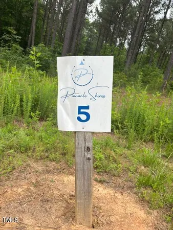 a sign board with tall trees