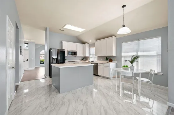a kitchen with white cabinets and stainless steel appliances