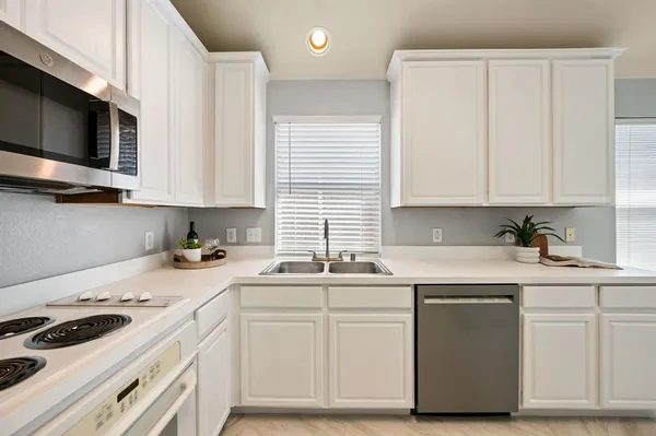 a kitchen with stainless steel appliances granite countertop a sink and a stove
