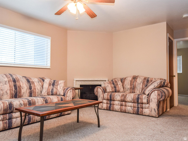 240 East 400 North, Unit 26 Logan, UT 84321 - Photo 2 of 10 Carpeted living area featuring ceiling fan and a fireplace