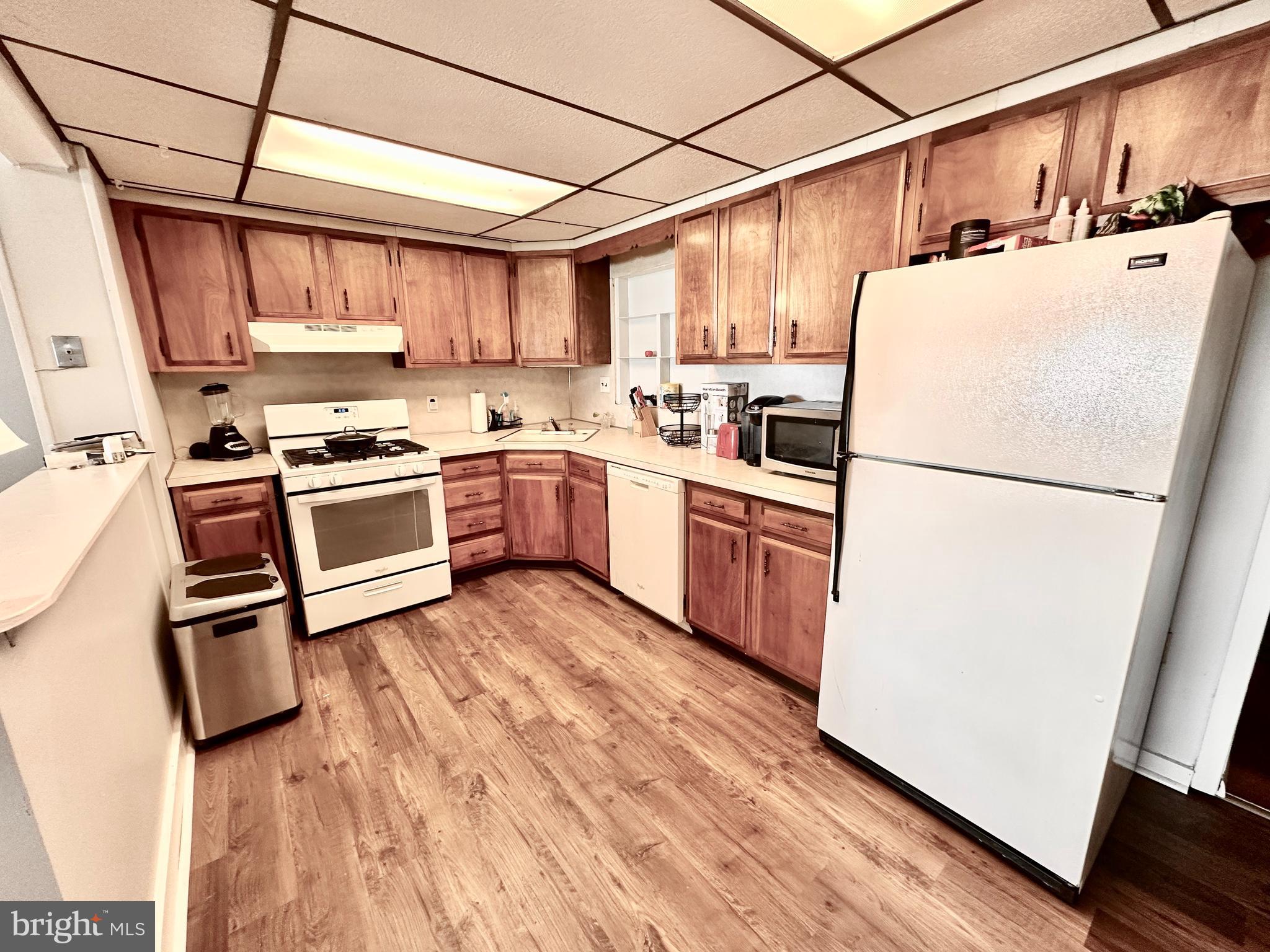 3339 Conrad Street, Unit 1 Philadelphia, PA 19129 - Photo 6 of 13 a kitchen with stainless steel appliances granite countertop a refrigerator a stove a sink dishwasher and white cabinets with wooden floor