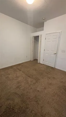 a view of an empty room with window and a ceiling fan